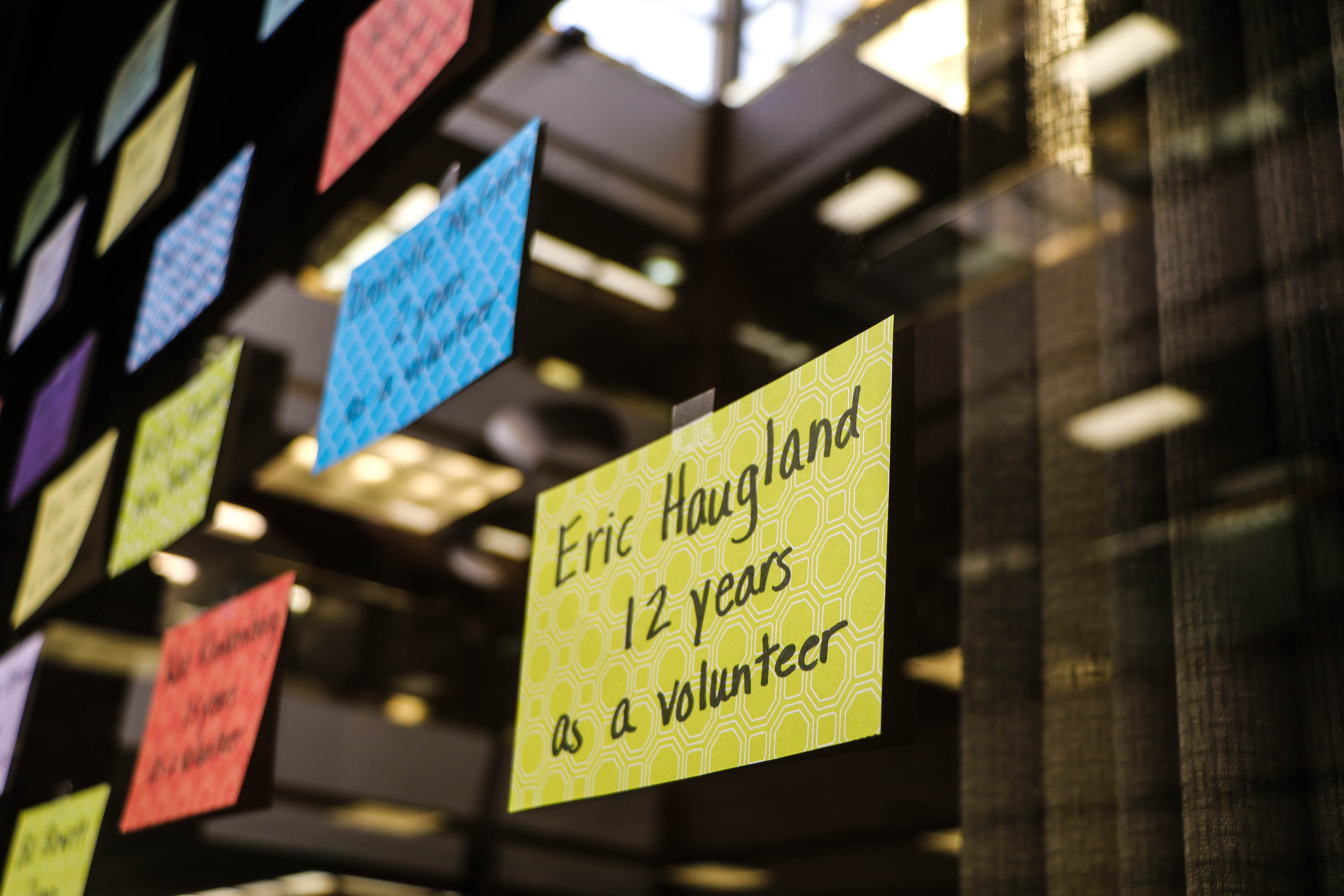 A sticky note on a window that reads, "Eric Haugland, 12 years as a volunteer"