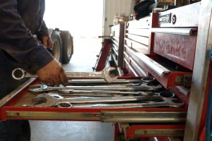 A trucker at Dakota Carriers pulling a wrench out of a toolbox.