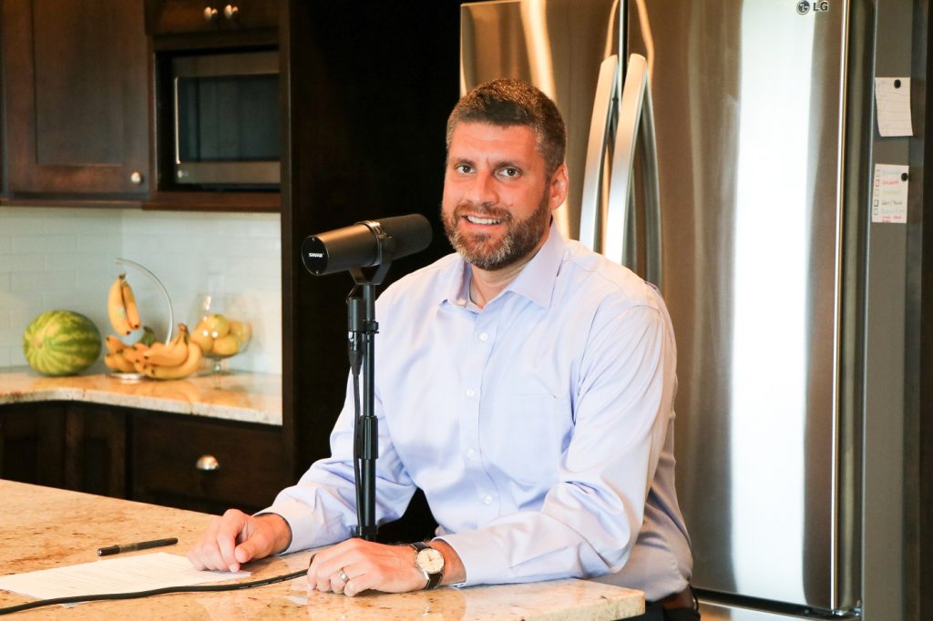 Adam Cox recording an episode of Common Cents on the Prairie in his kitchen during the COVID-19 pandemic.