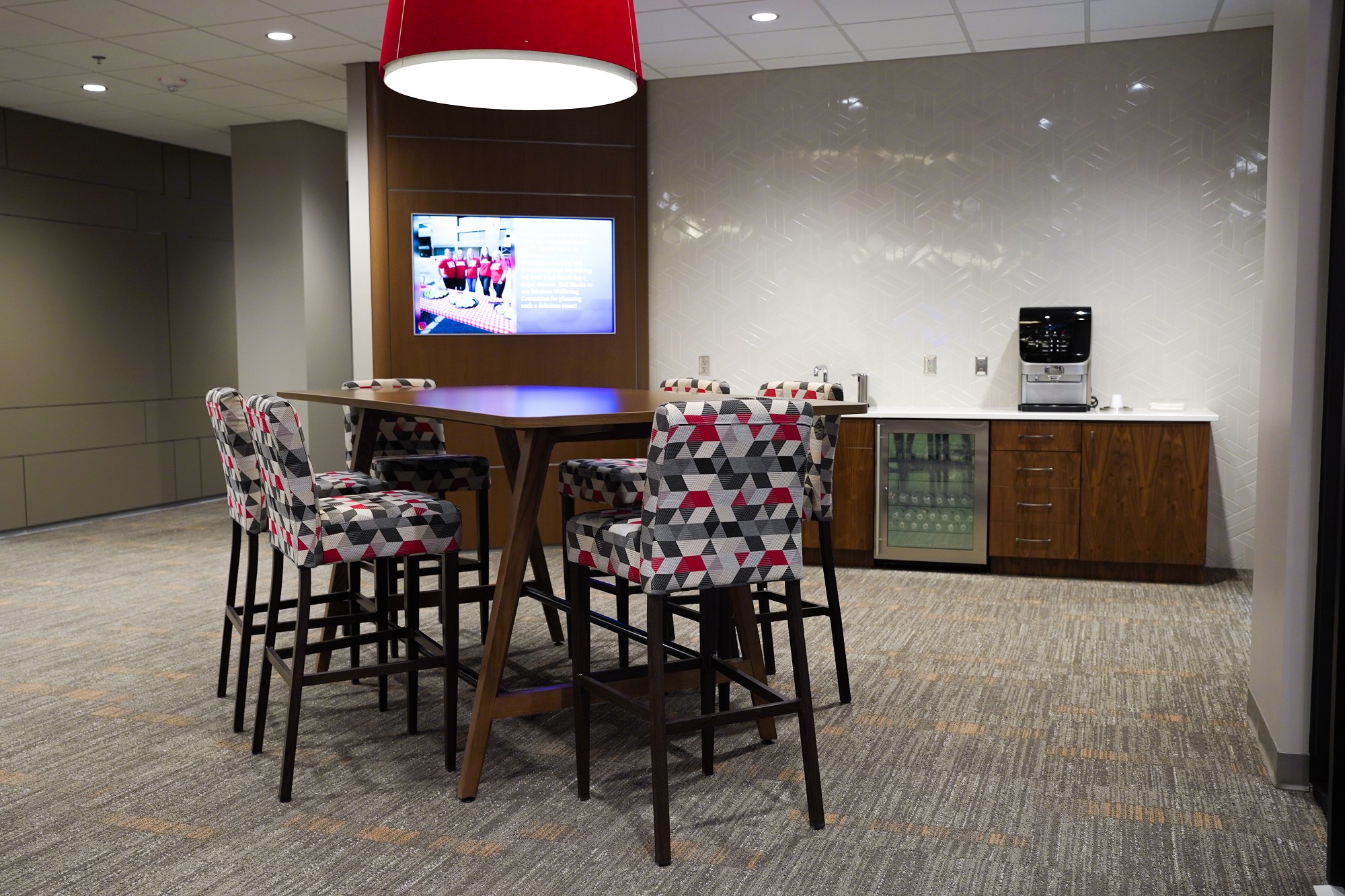 A high-rise table stands next to a beverage bar, welcoming customers into the new lobby.