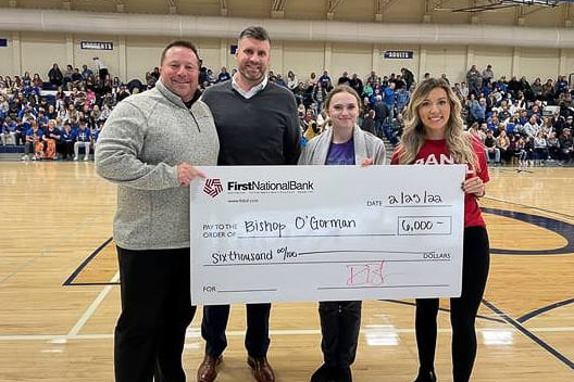 First National Bank distributing a Community Card check to Bishop O'Gorman Catholic Schools.