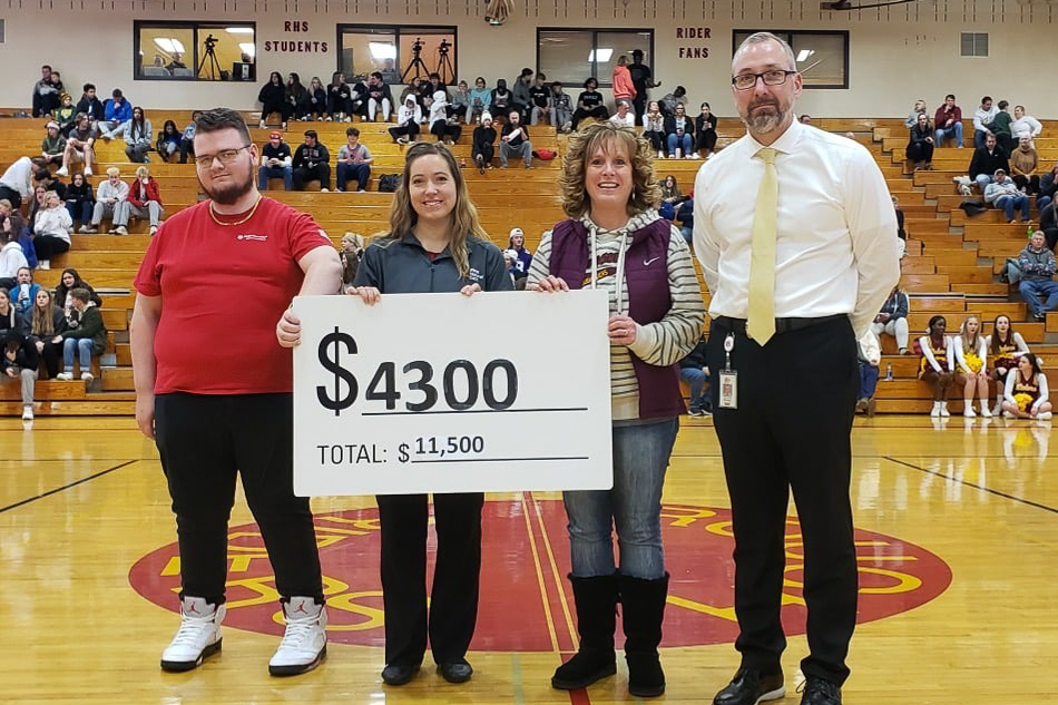 First National Bank distributing a Community Card check to Roosevelt High School.