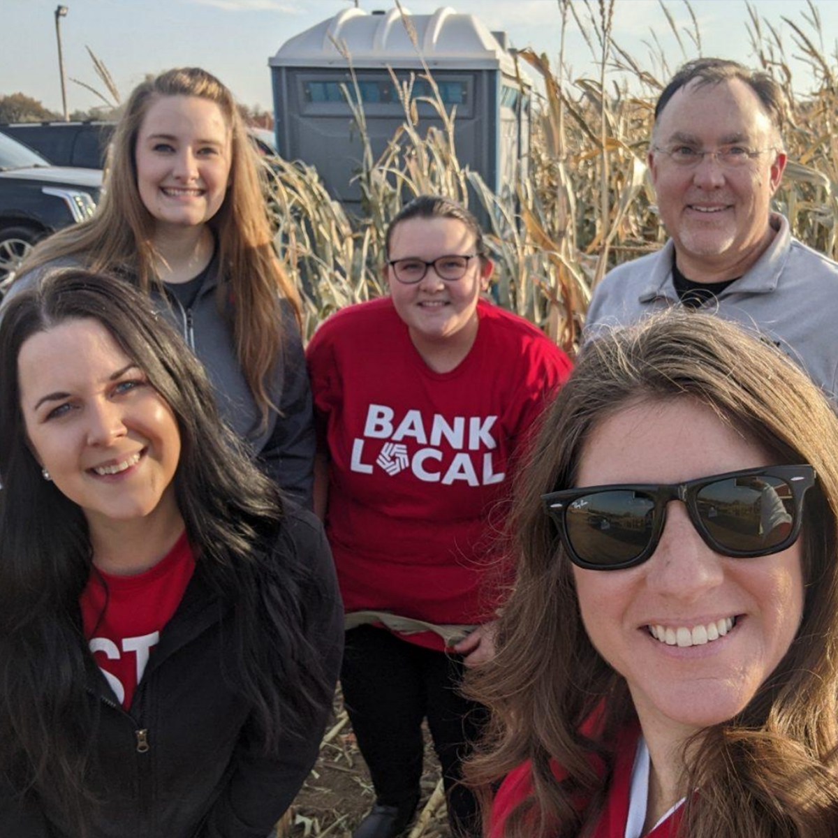First National Bank employees pose for selfie in front of Heartland Country Corn Maze in Harrisburg, SD.