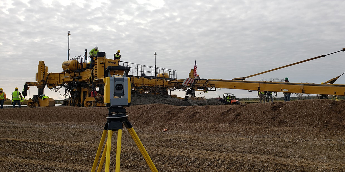 A road grater moving gravel on a construction site.