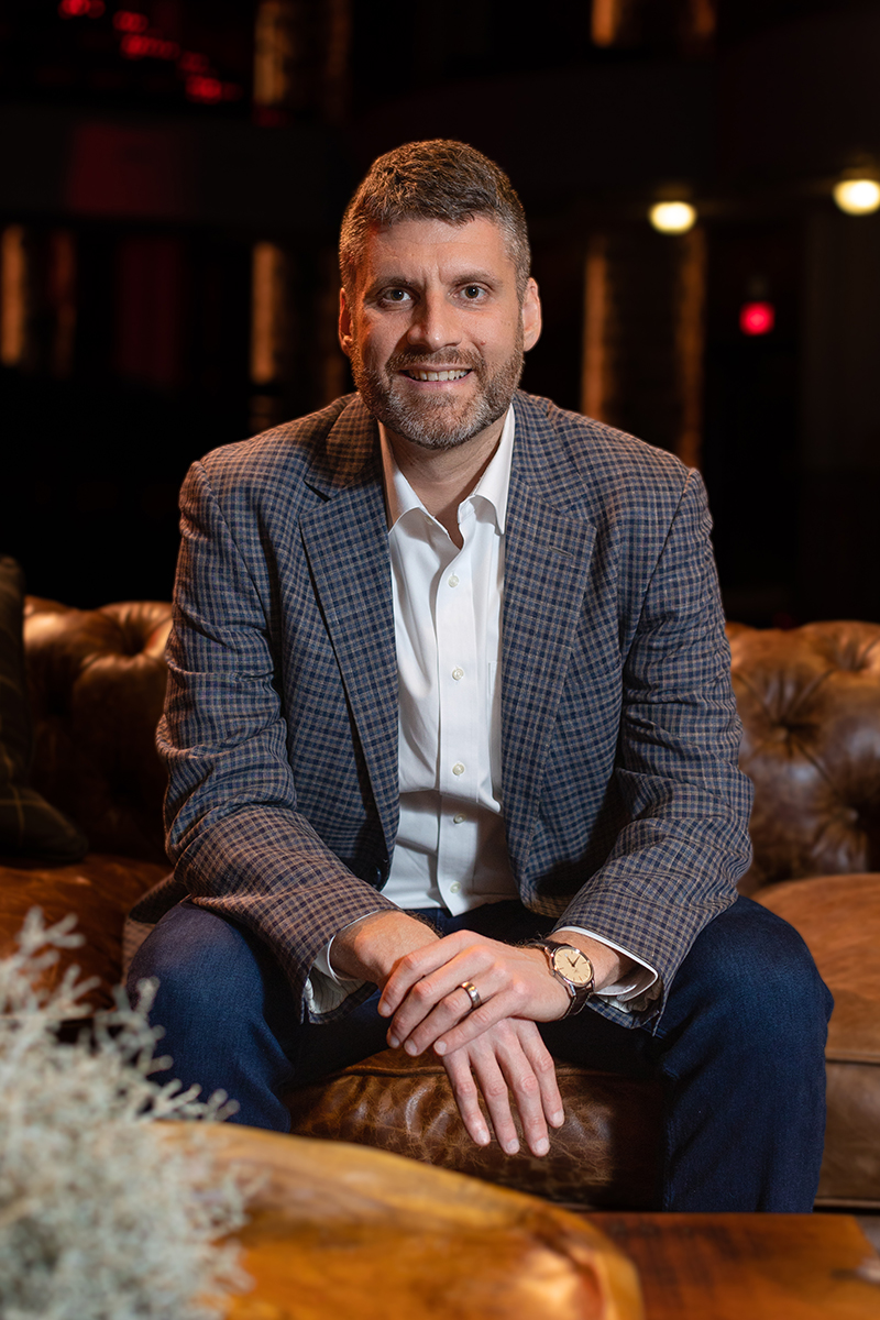 Adam Cox posing for a headshot on the set of the live Common Cents on the Prairie event.