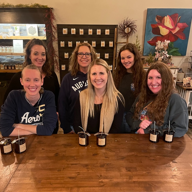 A group picture of First National Bank's Marketing team at a candle-making workshop.