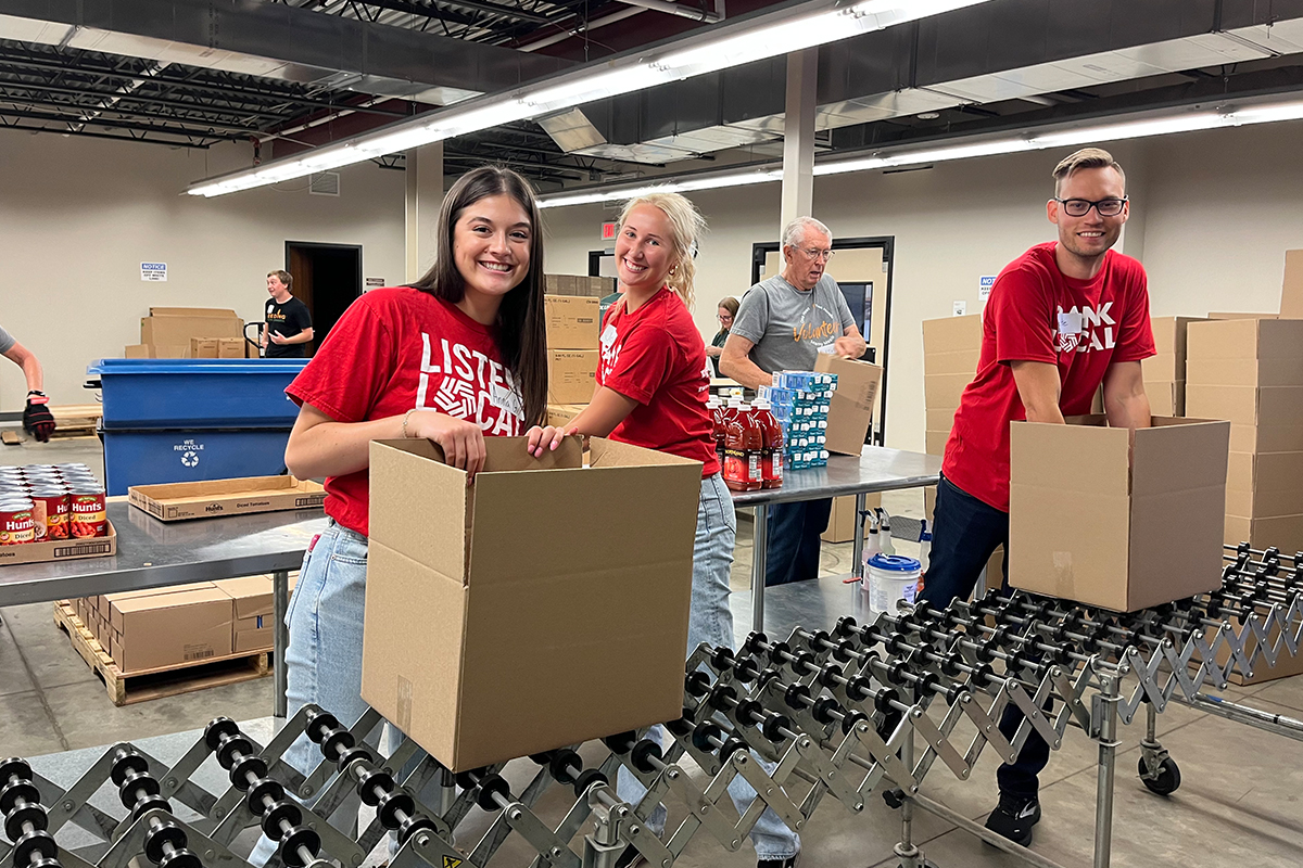 First National Bank teammates pack boxes at the Feeding South Dakota distribution center