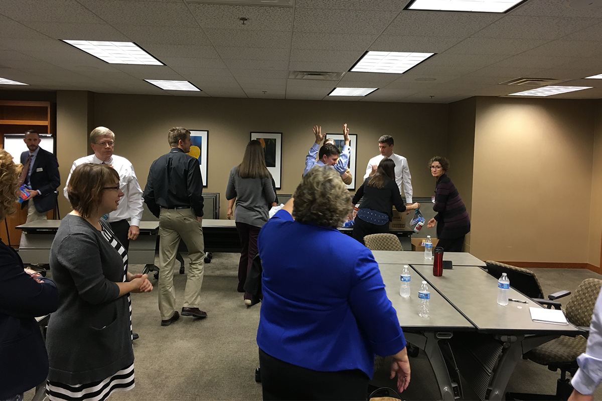 Teammates at First National Bank walk around a large room during a Culture Camp session.