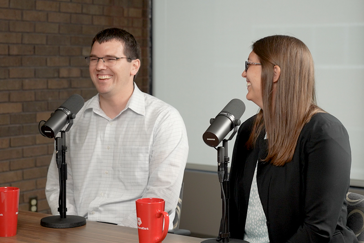 Brittany and Josh Evans laugh together while recording their podcast episode, "How We Money: Knocking Out Debt."