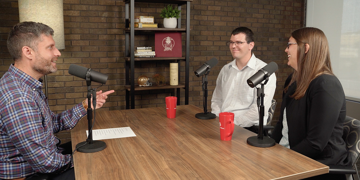 Adam Cox points at Brittany and Josh Evans while recording the podcast episode "How We Money: Knocking Out Debt."