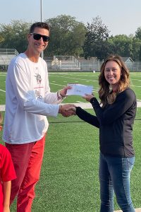 Val Lemkau presents a Community Card check to Dr. Jarod Larson.