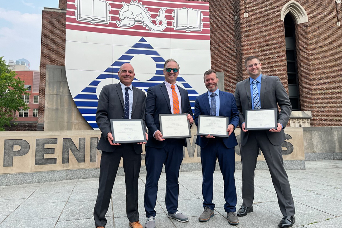 Seth Peterson and three other bankers pose with certificates at the Graduate School of Banking.