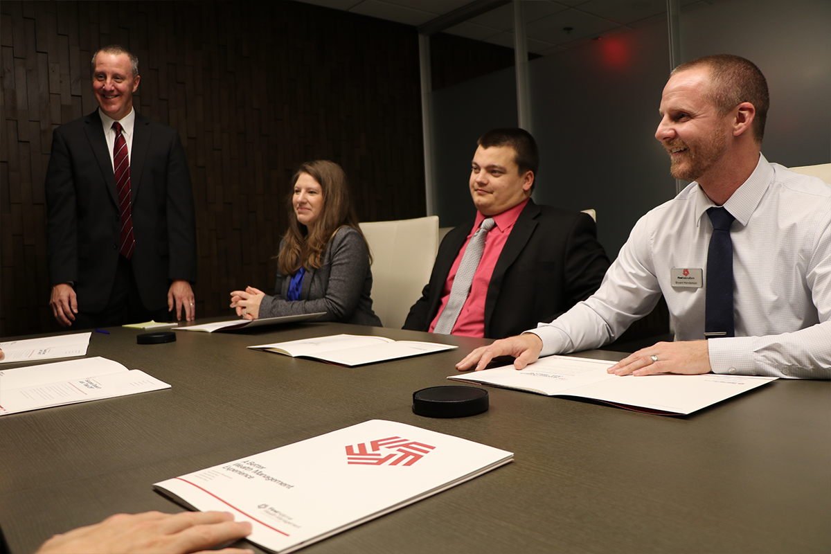 Members of the First National Wealth Management team meet around a conference room table.