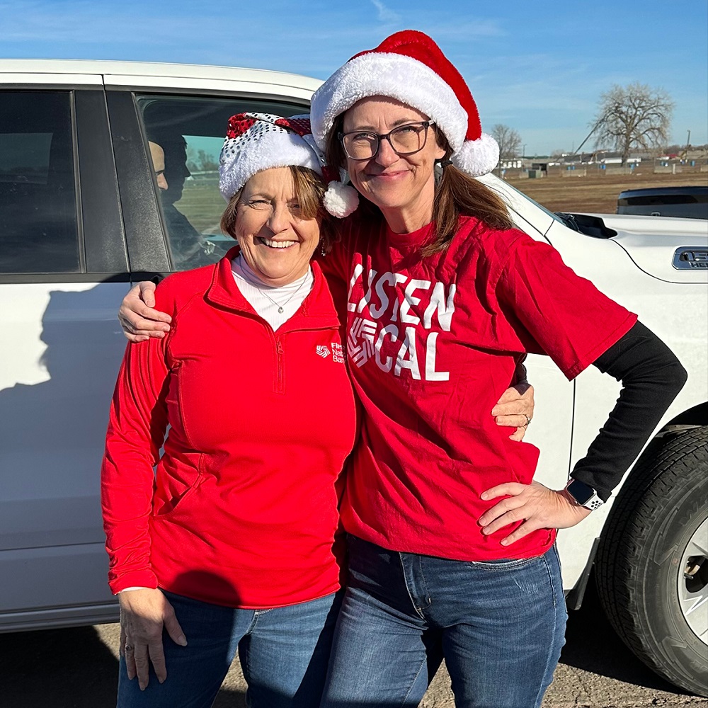 First National Bank employees wearing Santa hats as they volunteer with Sioux Falls Cares.