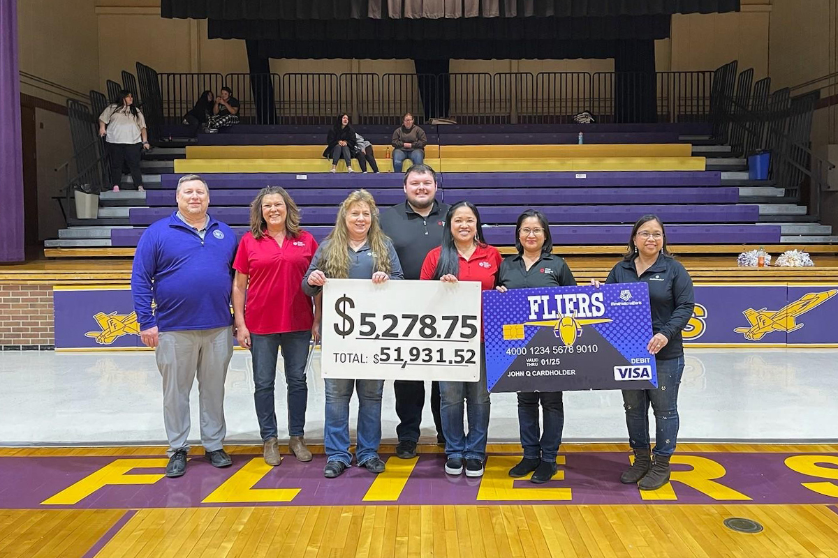 First National Bank employees present a check from the Community Card program to the Flandreau School District.