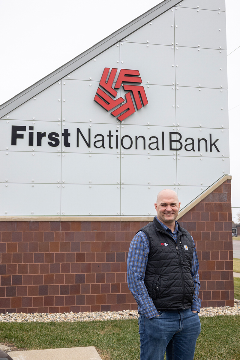 Ag Banker Phil DeGroot standing in front of a First National Bank sign.
