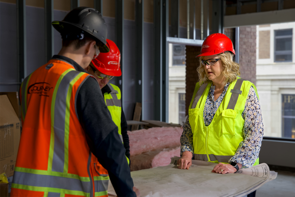 Facilities Experience Manager Kae Klinkenborg looking over floor plans with Journey Construction.