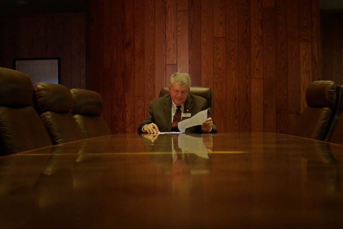 Bill Baker completing paperwork in First National Bank's board room.