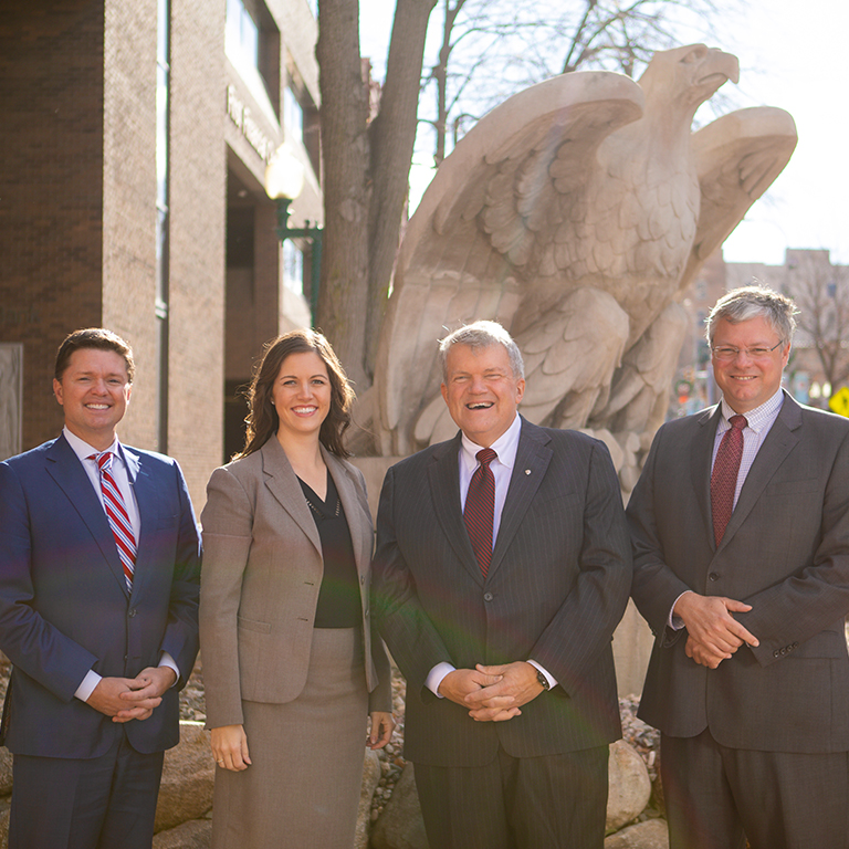 Chris Ekstrum, Maggie Groteluschen, Bob Baker, and Bill Baker in front of First National Bank.