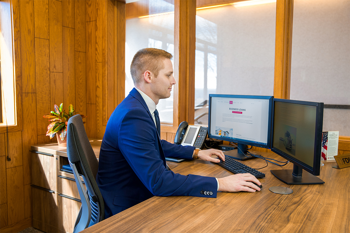 Mitch Janssen, FNB's new business banker, working at his desk in the Benson Road branch.