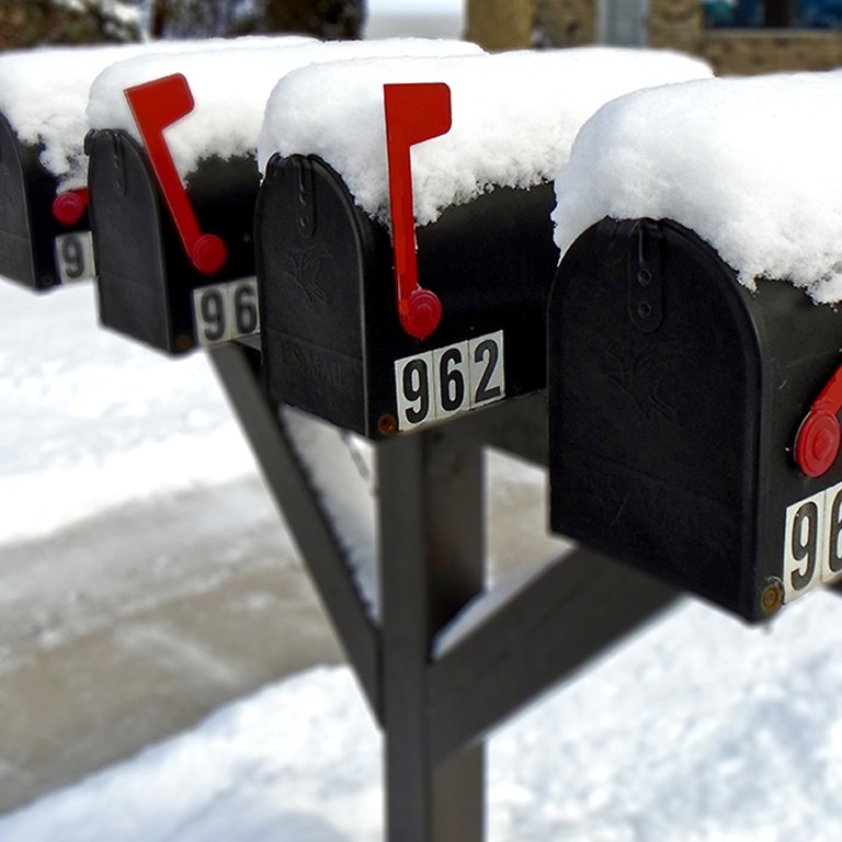 A row of snow-covered mailboxes.