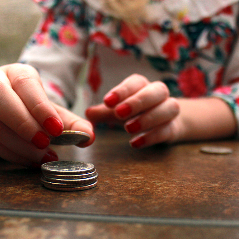A little girl stacking coins.