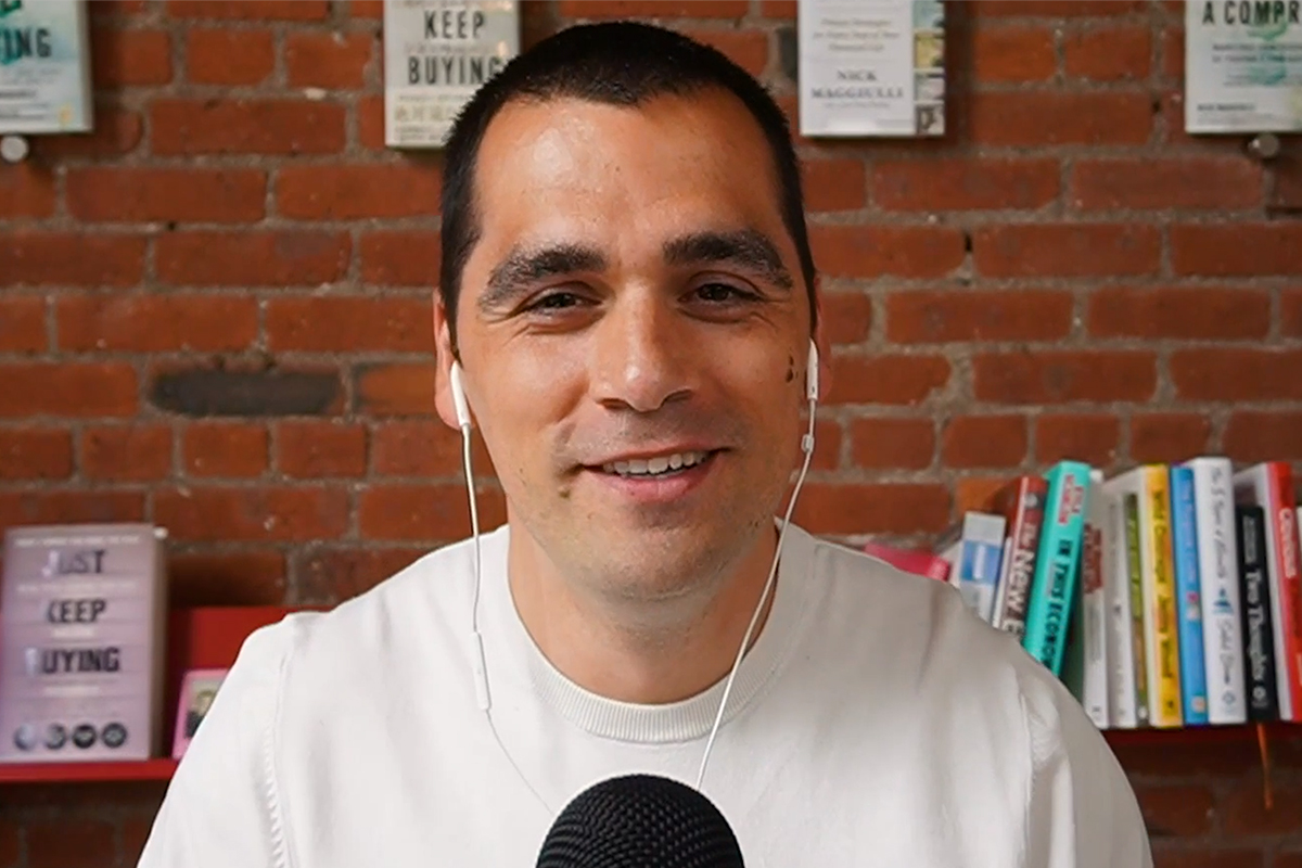 Nick Maggiulli wearing earbuds and smiling.