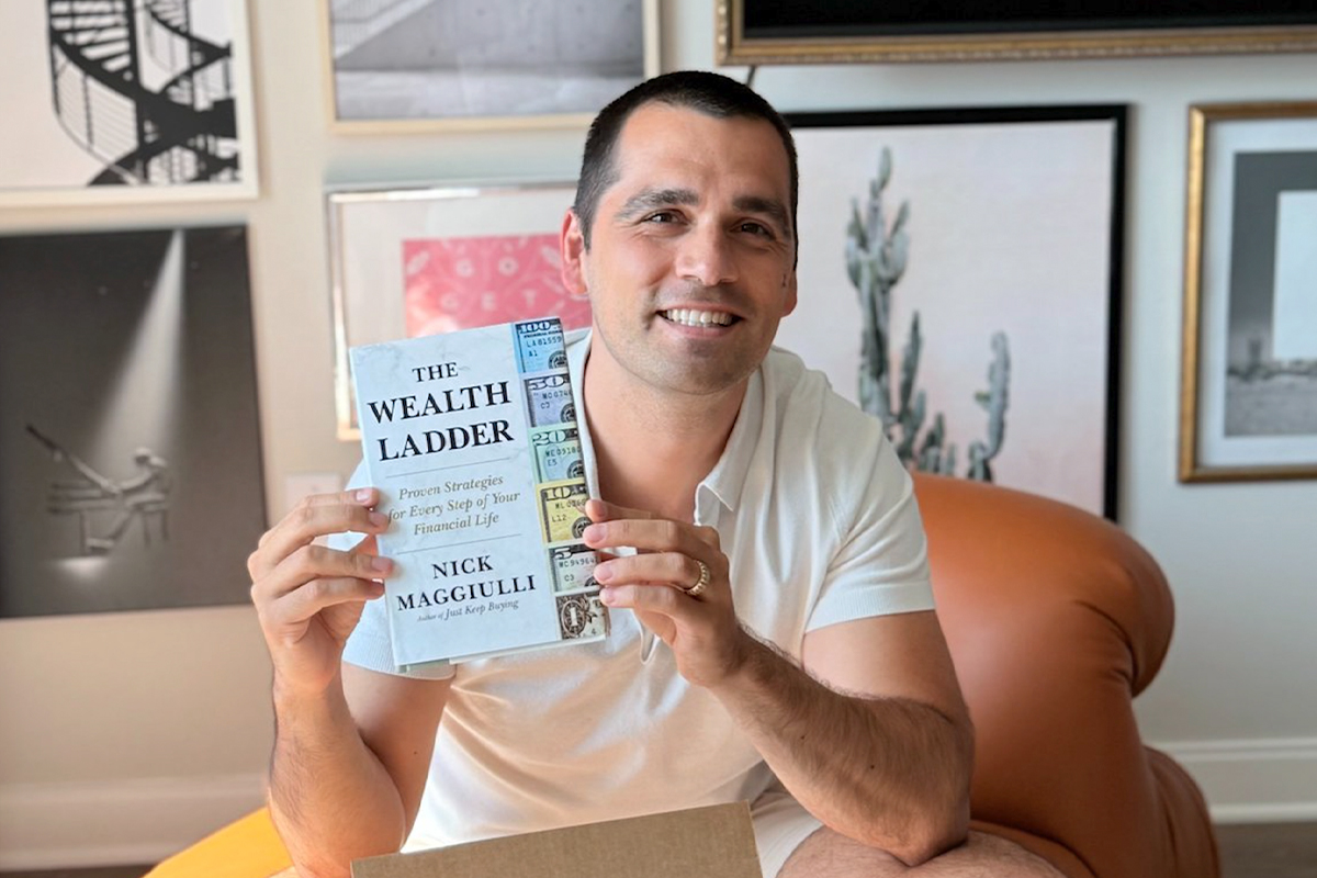 Nick Maggiulli holding his book "The Wealth Ladder."