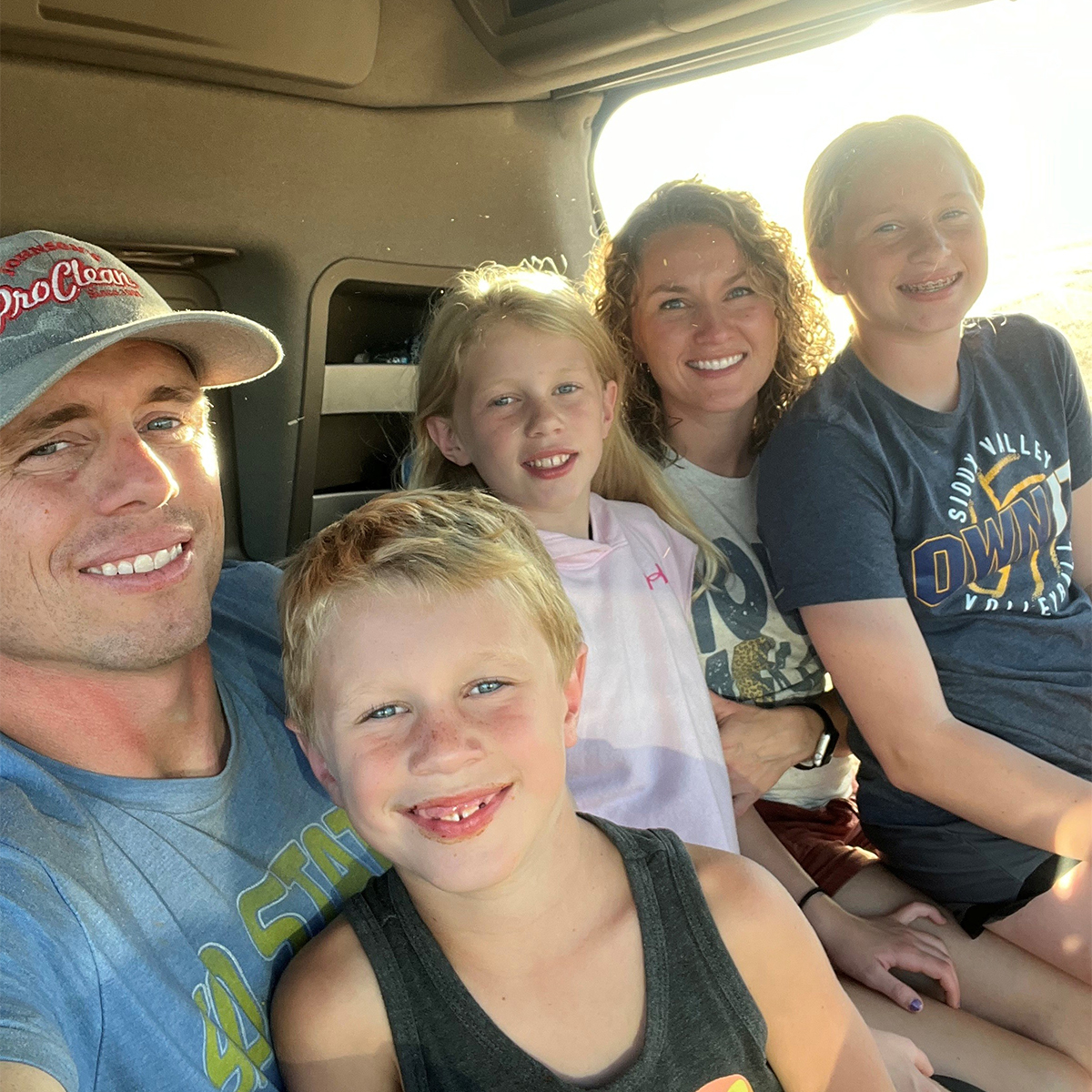 Sam Minor with his wife and three kids riding in a combine.