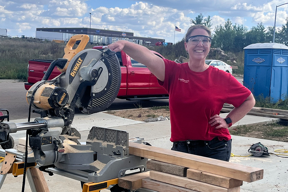 A woman posing with a power saw at Habitat for Humanity.