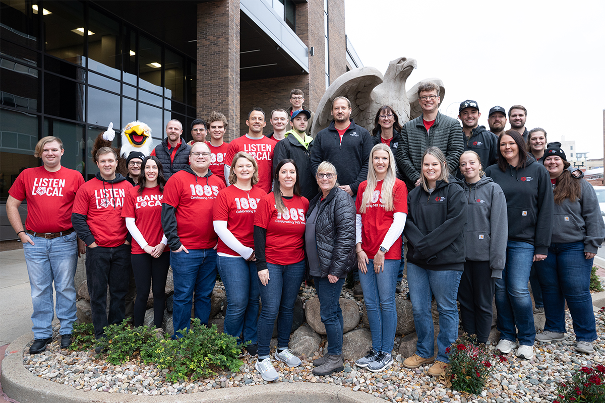 A group of people posing in front of the eagle statue in downtown Sioux Falls.