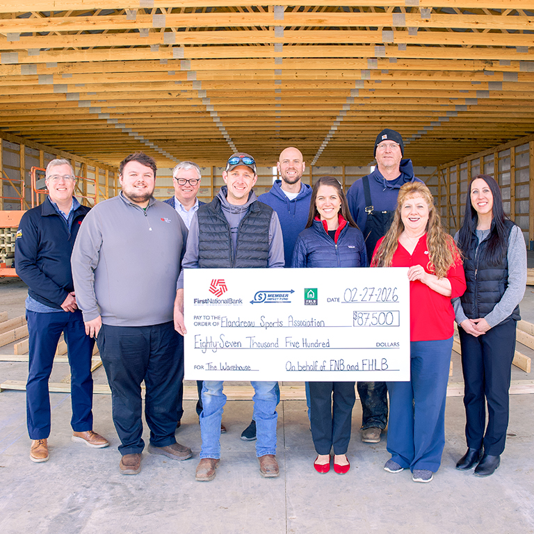 First National Bank presents a Member Impact Fund check to The Warehouse in Flandreau.