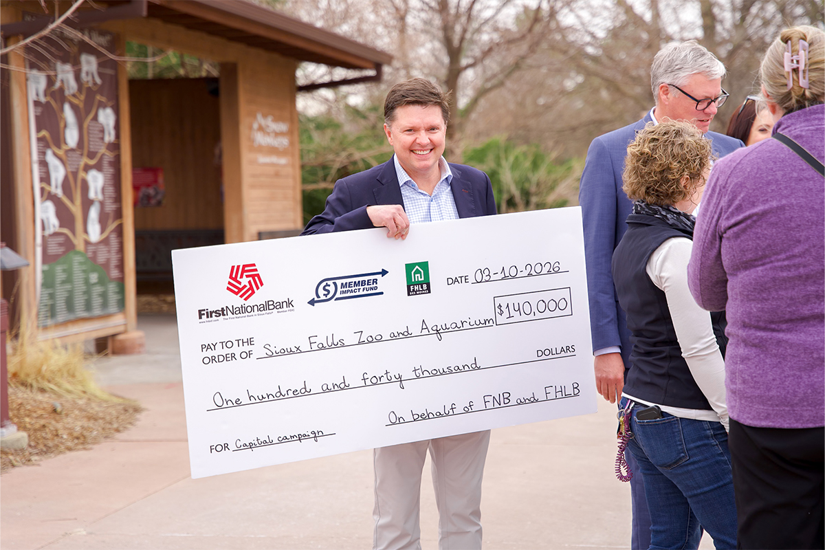 Chris Ekstrum holds the Member Impact Fund presentation check.