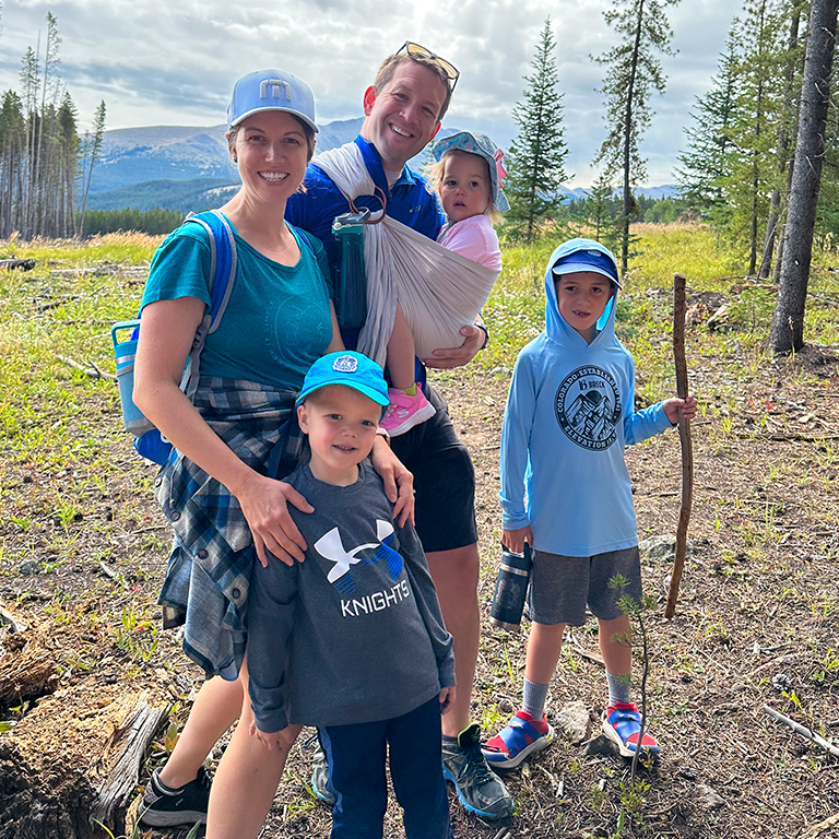 A family with three young kids hiking a national park.