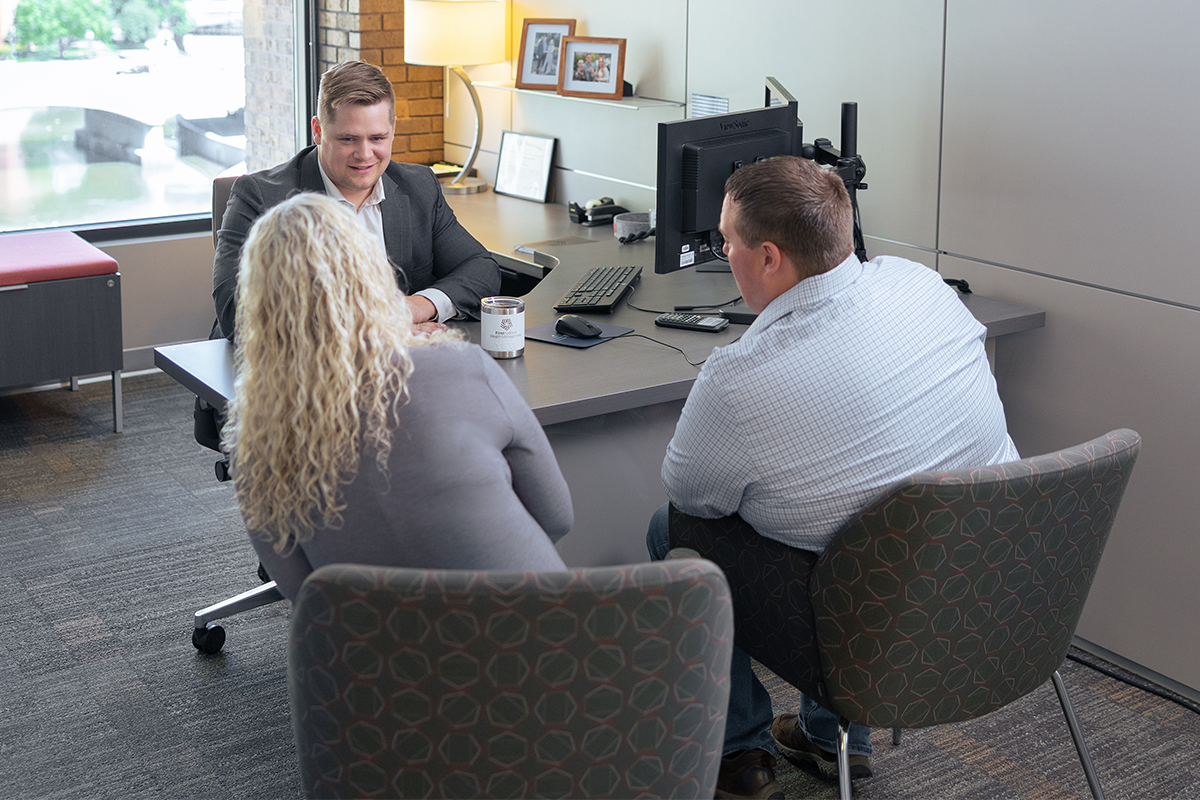 A financial advisor meeting with clients in an office.