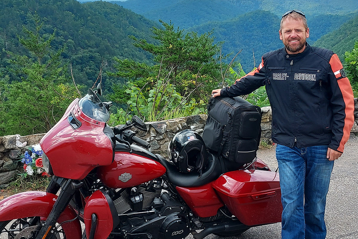 Kyle DeBoer posing for a photo with his motorcycle.