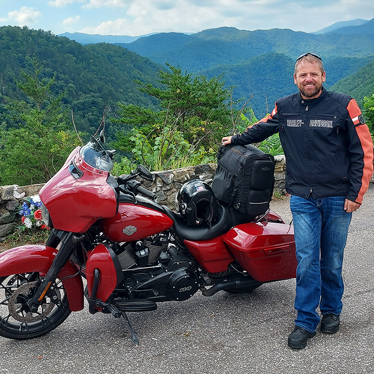 Kyle DeBoer posing for a photo with his motorcycle.